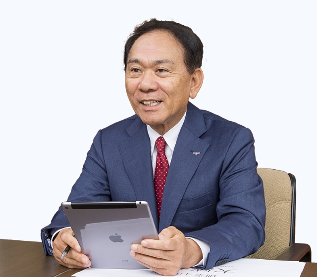 金田 達三CEOがタブレットを手にしている画像